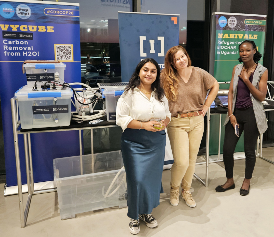 Dita Chowdhury, Laura Walker Chung and Sarah Nelima with the VYCUBE at COP28, Dubai